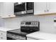 Modern kitchen with stainless steel appliances, white cabinets, and stylish backsplash at 23327 Christian Cir, Brooksville, FL 34601