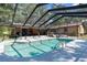 A refreshing pool within a screened enclosure, complemented by a brick house and an inviting outdoor seating area at 23327 Christian Cir, Brooksville, FL 34601