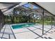 Relaxing screened pool with a clear blue water view of the lush backyard with beautiful trees at 23327 Christian Cir, Brooksville, FL 34601