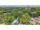 High aerial shot of a neighborhood filled with mature trees and lush greenery, near a sprawling city at 2512 W Jetton Ave, Tampa, FL 33629