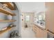 Bright bathroom featuring a double vanity with modern fixtures, open shelving, and a glass-enclosed shower at 2512 W Jetton Ave, Tampa, FL 33629