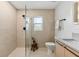 Walk in shower with beige tile and glass wall, with a small wooden stool inside at 2512 W Jetton Ave, Tampa, FL 33629