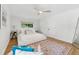Bright bedroom featuring a ceiling fan, neutral bedding, and wood floors at 2512 W Jetton Ave, Tampa, FL 33629