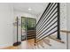 The stylish entryway features modern staircase, unique wallpaper, and a sleek coat rack near the front door at 2512 W Jetton Ave, Tampa, FL 33629