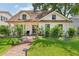 Charming home boasts a lush green lawn and brick pathway leading to a welcoming front porch with unique architectural details at 2512 W Jetton Ave, Tampa, FL 33629
