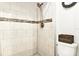 Bathroom shower area with white tiled walls and accent tile, featuring modern fixtures and a clean design at 269 Los Prados Dr # 1011, Safety Harbor, FL 34695