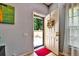 Bright entryway showcasing an open door with a screen, a red rug, and view of the front terrace at 269 Los Prados Dr # 1011, Safety Harbor, FL 34695