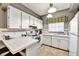 Bright kitchen featuring white cabinets, tiled countertops, and modern appliances for a classic, clean design at 269 Los Prados Dr # 1011, Safety Harbor, FL 34695
