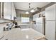 Bright kitchen featuring white cabinets, tiled countertops, and modern appliances for a classic, clean design at 269 Los Prados Dr # 1011, Safety Harbor, FL 34695