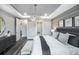 Bright main bedroom with a large chandelier, horizontal accent wall, and ensuite bathroom at 27124 Capri Shores Cir, Englewood, FL 34223