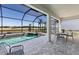 Relaxing screened patio featuring a pool and spa with a serene waterfront view and comfortable seating at 27124 Capri Shores Cir, Englewood, FL 34223