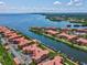 Aerial shot of waterfront condo complex with boat docks, terracotta roofs, and beautiful landscaping at 2733 Via Cipriani # 830B, Clearwater, FL 33764