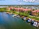 Aerial shot of waterfront condos with boat docks, surrounded by lush greenery and community amenities at 2733 Via Cipriani # 830B, Clearwater, FL 33764