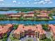 Aerial view of waterfront community with terracotta roofs and lush landscaping in a serene setting at 2733 Via Cipriani # 830B, Clearwater, FL 33764