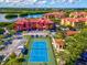 Aerial view of community featuring a tennis court, parking, and well-maintained landscaping at 2733 Via Cipriani # 830B, Clearwater, FL 33764