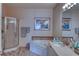 Relaxing bathroom with a soaking tub, a separate shower, and elegant fixtures for a spa-like experience at 2733 Via Cipriani # 830B, Clearwater, FL 33764