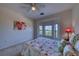 Cozy bedroom featuring a floral bedspread, ceiling fan, and a large window to enhance natural lighting at 2733 Via Cipriani # 830B, Clearwater, FL 33764