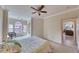 Comfortable bedroom featuring a floral bedspread, ceiling fan, and cozy sitting area by a bright window at 2733 Via Cipriani # 830B, Clearwater, FL 33764