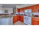This well-lit kitchen features wood cabinetry, granite countertops, and modern appliances, including a white gas range at 2733 Via Cipriani # 830B, Clearwater, FL 33764