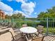 Comfortable outdoor patio seating with a table and chairs overlooking a serene lake and beautiful landscaping at 2733 Via Cipriani # 830B, Clearwater, FL 33764