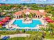 Aerial view of a luxurious pool area surrounded by palm trees and lounge chairs, perfect for relaxation at 2733 Via Cipriani # 830B, Clearwater, FL 33764