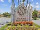 The entrance sign for 'Grand Bellagio' is surrounded by vibrant flowers and lush greenery at 2733 Via Cipriani # 830B, Clearwater, FL 33764