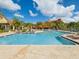 Large outdoor pool surrounded by lounge chairs, cabanas, and lush landscaping at 2733 Via Cipriani # 830B, Clearwater, FL 33764