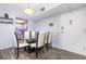 Dining room with a glass table, six chairs, wood-look floors, light fixture and a view to the kitchen at 2901 26Th W St # 815, Bradenton, FL 34205