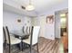 Dining room with modern table and view of kitchen and hall. Features wood-look floors and updated light fixture at 2901 26Th W St # 815, Bradenton, FL 34205