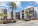 Exterior view of a multi-story condo building with balconies, landscaping, and a parking lot with palm trees at 2901 26Th W St # 815, Bradenton, FL 34205