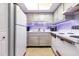 Functional kitchen with white appliances, wooden cabinets, modern counter tops, and a light fixture at 2901 26Th W St # 815, Bradenton, FL 34205