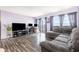 Open concept living room featuring wood floors, gray sofa, office area with two computer monitors and exterior views at 2901 26Th W St # 815, Bradenton, FL 34205