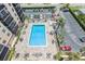 Aerial view of a community pool with lounge chairs, tables, tropical plants, and a parking lot at 2901 26Th W St # 815, Bradenton, FL 34205