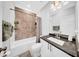 Modern bathroom with bathtub, patterned tile accent wall, granite vanity, and contemporary fixtures at 3013 W Crest Ave, Tampa, FL 33614
