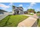 Well-maintained home features a lush green lawn and a driveway leading to the attached garage, adding to its charm at 3013 W Crest Ave, Tampa, FL 33614