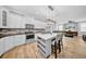 Contemporary kitchen flows into the living area, featuring white cabinets, and an island with barstool seating at 3013 W Crest Ave, Tampa, FL 33614