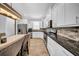 Well-equipped kitchen with white cabinets, stone backsplash, granite countertops, and stainless steel appliances at 3013 W Crest Ave, Tampa, FL 33614