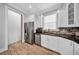 Bright kitchen with stainless steel appliances, white cabinets, stone backsplash, and wood-look tile flooring at 3013 W Crest Ave, Tampa, FL 33614