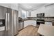 Modern kitchen features stainless steel appliances, white cabinets, stone backsplash, and an eat-in bar at 3013 W Crest Ave, Tampa, FL 33614