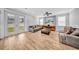 Comfortable living room featuring neutral tones, wood-look tile flooring, modern lighting, and an exterior view at 3013 W Crest Ave, Tampa, FL 33614