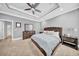 Spacious primary bedroom featuring tray ceiling, fan, bedside tables, and ensuite bathroom at 3013 W Crest Ave, Tampa, FL 33614