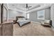 This gray main bedroom features a tray ceiling, ceiling fan, carpet, and lots of natural light at 3013 W Crest Ave, Tampa, FL 33614
