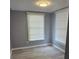 This bedroom has two windows with blinds and updated flooring at 305 E Adalee St, Tampa, FL 33603