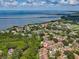 An aerial view of the tan townhome community with views of a bridge and blue water in the background at 3077 Branch Dr, Clearwater, FL 33760