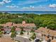 Beautiful aerial view of tan townhomes with garages and manicured landscaping and blue bay in the background at 3077 Branch Dr, Clearwater, FL 33760