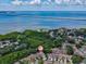 An aerial view showcasing brown townhomes near lush mangroves and blue water, under a clear sky at 3077 Branch Dr, Clearwater, FL 33760