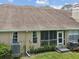 View of the back of the house, including the screened-in porch, windows, and yard at 3077 Branch Dr, Clearwater, FL 33760