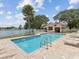 Community pool with a bathhouse and clear blue water, surrounded by well-maintained deck and landscaping at 3077 Branch Dr, Clearwater, FL 33760