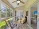 Relaxing sunroom features a ceiling fan, tiled floor and sliding doors to outside at 3077 Branch Dr, Clearwater, FL 33760