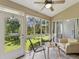 Inviting sunroom with tiled flooring, a ceiling fan and sliding glass doors to backyard at 3077 Branch Dr, Clearwater, FL 33760